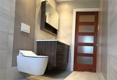 Installation d'une toilette murale Toto, douche sans seuil de Schluter, vanité et pharmacie Vanico et céramique mûr à mûr. Travaux de rénovation de salle de bain réalisés à Chambly sur la rive-sud de Montréal.