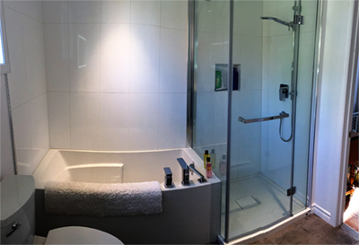 Rénovation de salle de bain avec les services d'un designer. Installation d'une douche et baignoire Zita, système d'étanchéité Schluter, mobilier et équipement. Travaux de rénovation de salle de bain réalisés à Chambly sur la rive-sud de Montréal.